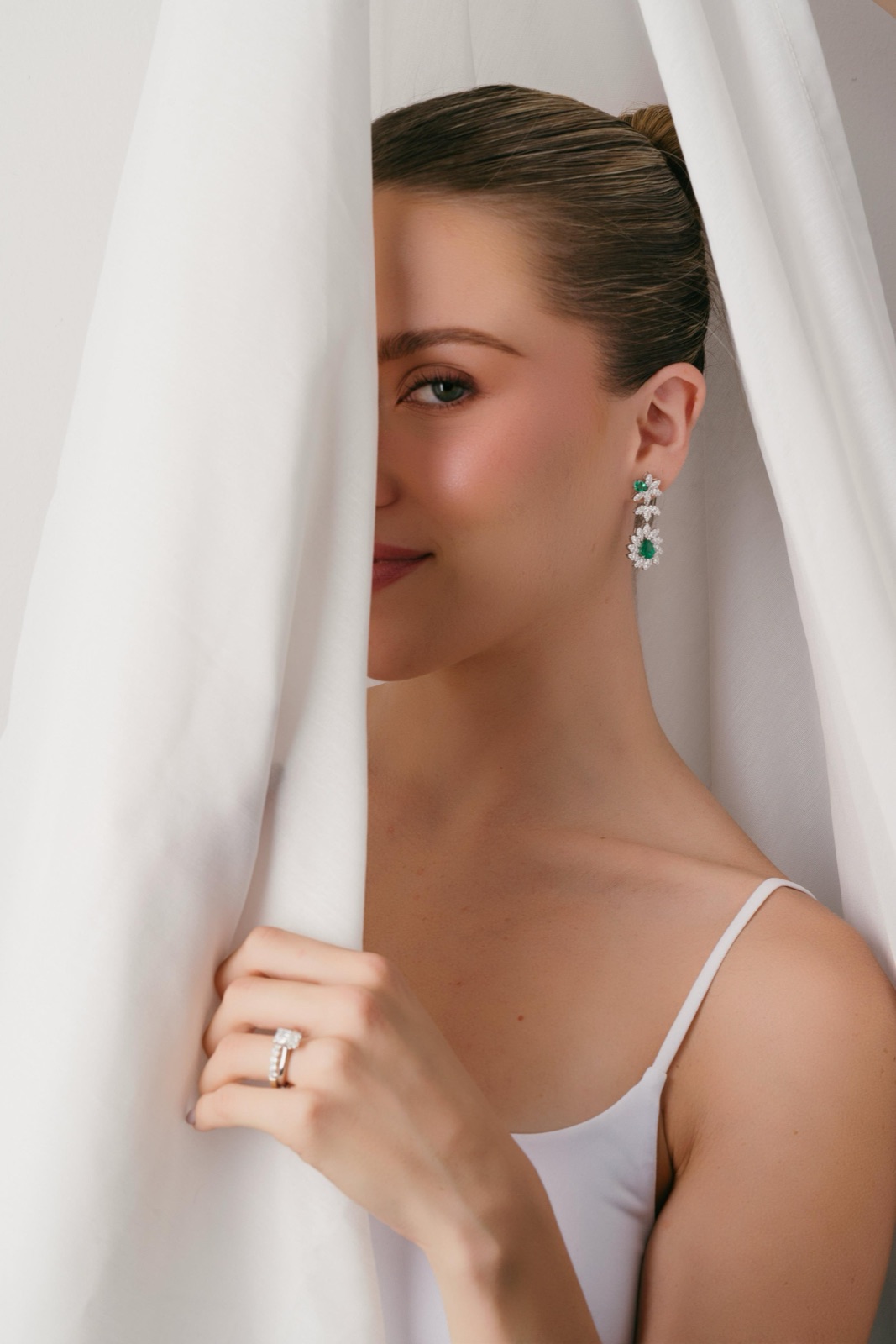 Modelo con arracadas ELJA de esmeraldas y diamantes