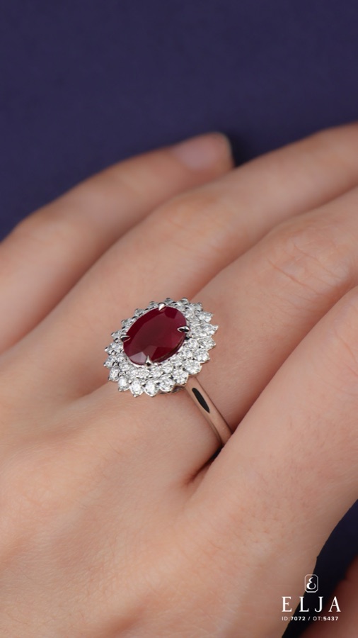 Anillo de rubí y diamantes en mano, símbolo de romance verdadero